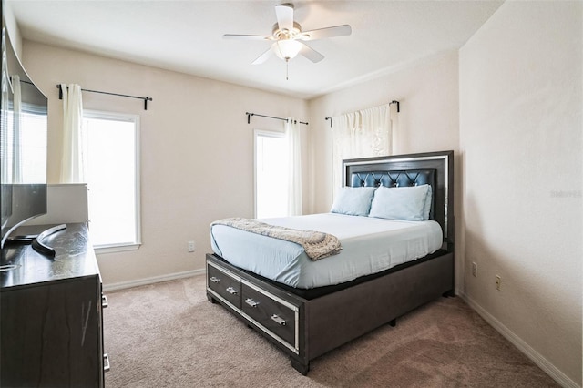 bedroom featuring multiple windows, light carpet, and baseboards