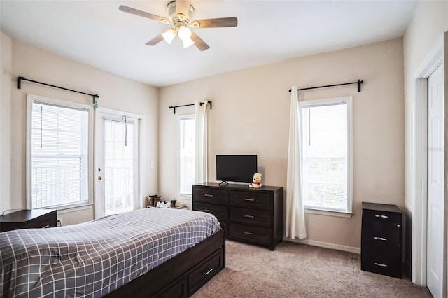 bedroom with baseboards, multiple windows, light carpet, and ceiling fan