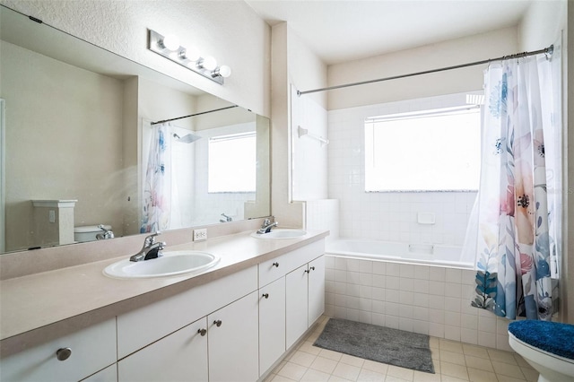 full bathroom with toilet, tiled shower / bath combo, and a sink