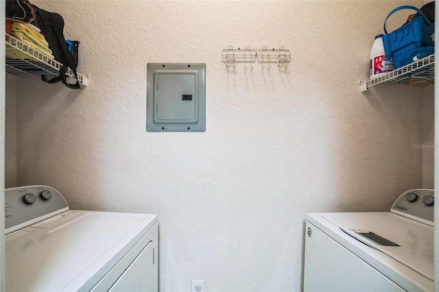 laundry area featuring washer and clothes dryer, laundry area, electric panel, and a textured wall