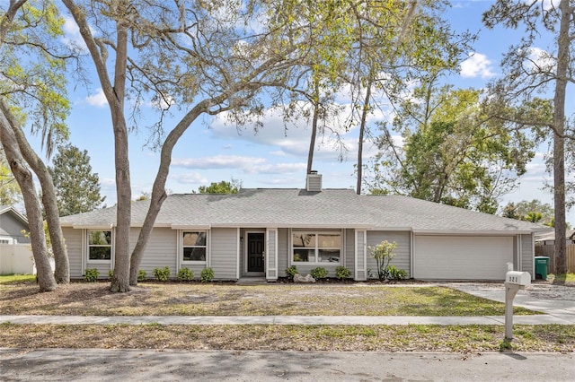 single story home featuring driveway, fence, a shingled roof, a garage, and a chimney