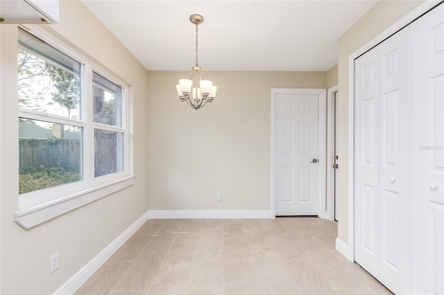 interior space featuring baseboards and an inviting chandelier