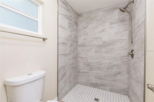 bathroom with a stall shower, toilet, and a textured ceiling