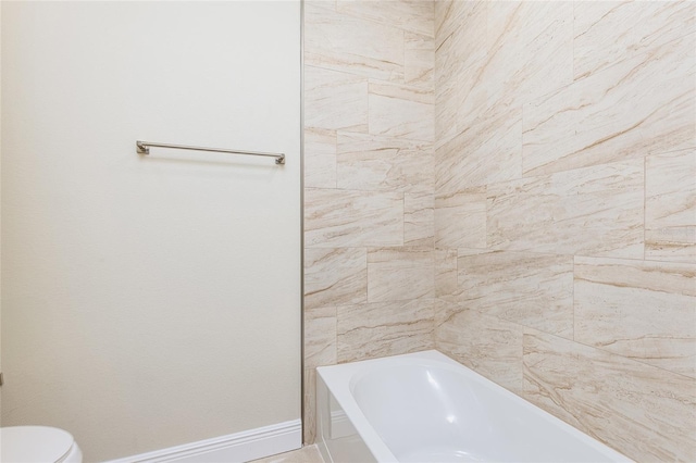 full bathroom with toilet and baseboards