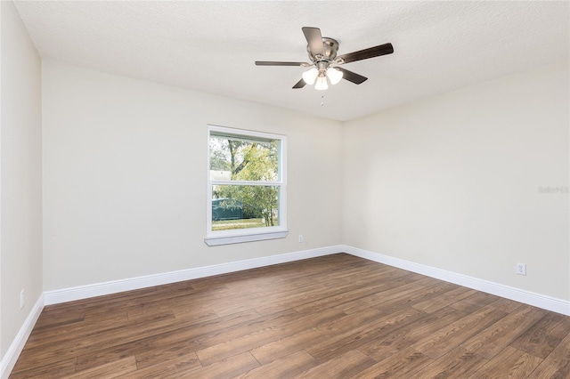 empty room featuring ceiling fan, baseboards, a textured ceiling, and dark wood finished floors