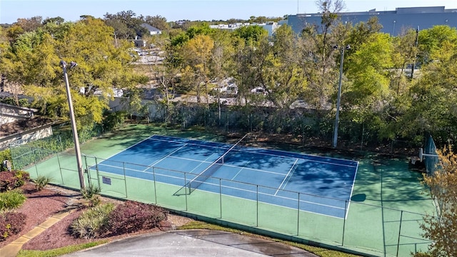 view of tennis court featuring fence