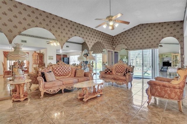 living area featuring arched walkways, visible vents, wallpapered walls, and a ceiling fan