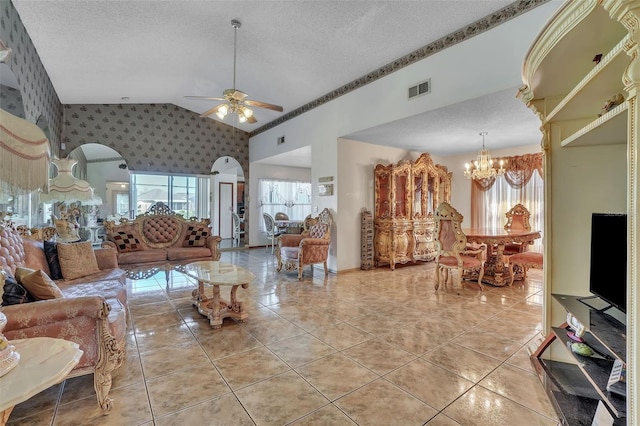 living room with visible vents, arched walkways, a textured ceiling, and wallpapered walls