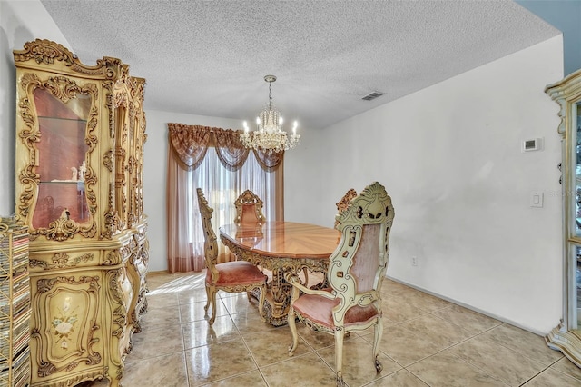 dining area featuring a textured ceiling, light tile patterned floors, visible vents, and a chandelier