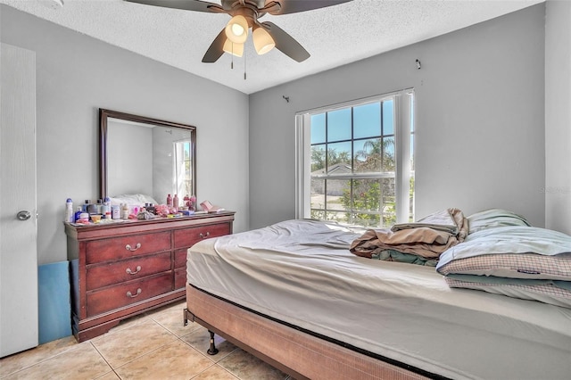 bedroom featuring light tile patterned flooring, a textured ceiling, and a ceiling fan