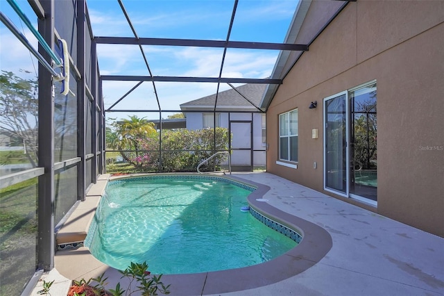 pool featuring glass enclosure and a patio