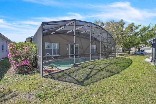 back of property featuring glass enclosure, a yard, and an outdoor pool