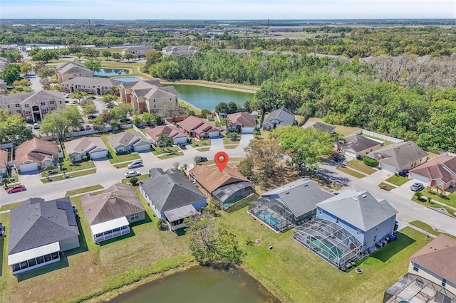 birds eye view of property with a residential view, a wooded view, and a water view