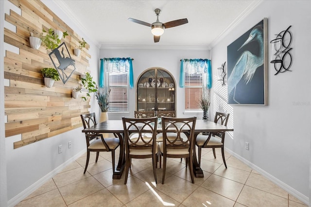 dining room with light tile patterned floors, baseboards, crown molding, and ceiling fan