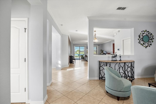 hall featuring light tile patterned floors, visible vents, crown molding, and baseboards