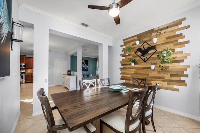 dining room featuring visible vents, baseboards, ceiling fan, ornamental molding, and light tile patterned floors