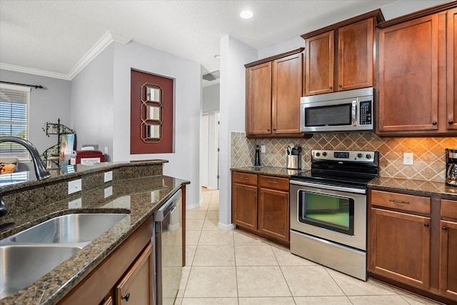 kitchen with light tile patterned flooring, backsplash, stainless steel appliances, and a sink