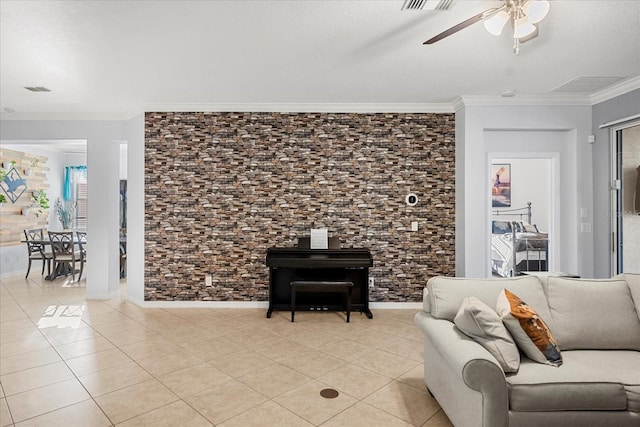 living room featuring light tile patterned floors, visible vents, a ceiling fan, and ornamental molding