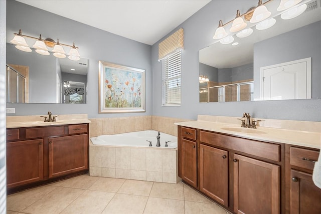 full bath featuring a garden tub, two vanities, a stall shower, tile patterned floors, and a sink