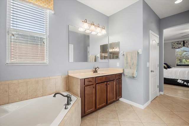 ensuite bathroom with tile patterned flooring, baseboards, vanity, a garden tub, and ensuite bath