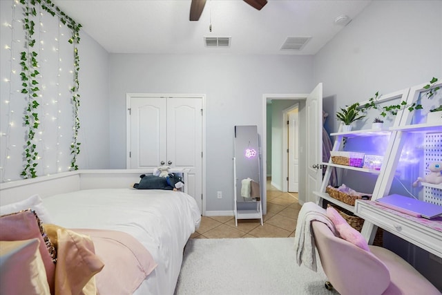 bedroom with light tile patterned floors, visible vents, a closet, and ceiling fan