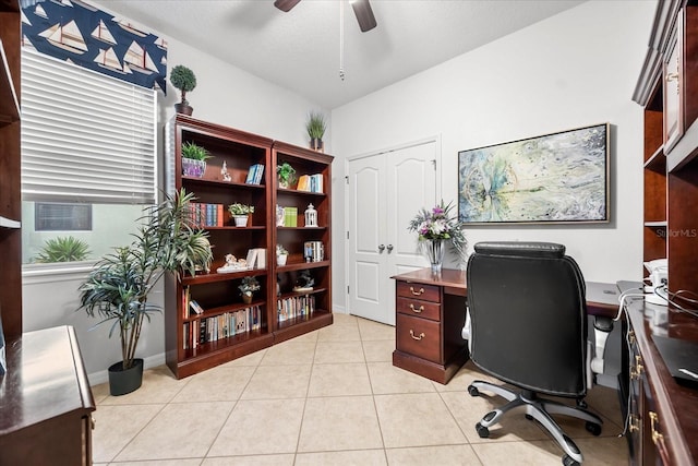 office area with lofted ceiling, light tile patterned floors, a ceiling fan, and baseboards