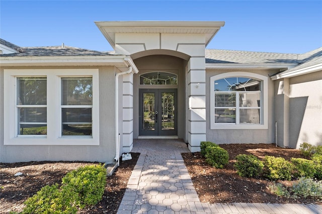8611 Dover Oaks Ct, Orlando, FL 32836 - view of exterior entry with roof with shingles, french doors, and stucco siding