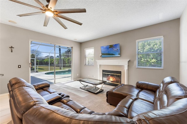 8611 Dover Oaks Ct, Orlando, FL 32836 - living room featuring ceiling fan, a sunroom, a textured ceiling, carpet floors, and a tile fireplace