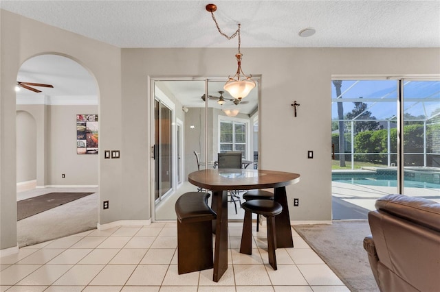 8611 Dover Oaks Ct, Orlando, FL 32836 - dining room featuring light tile patterned floors, baseboards, ceiling fan, a textured ceiling, and light colored carpet