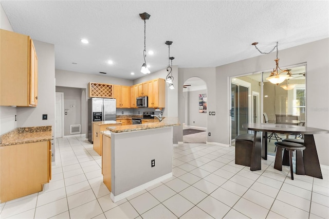 8611 Dover Oaks Ct, Orlando, FL 32836 - kitchen featuring light tile patterned floors, a textured ceiling, arched walkways, visible vents, and stainless steel appliances
