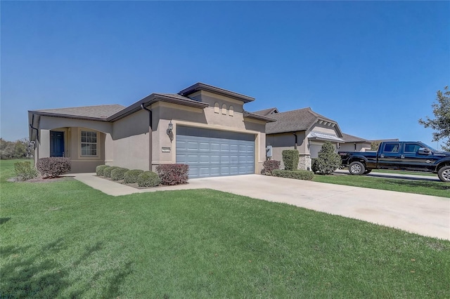 view of front of home with stucco siding, a front yard, a garage, and driveway