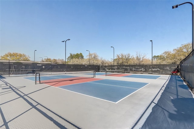 view of tennis court featuring fence