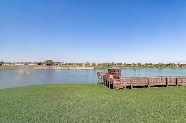 dock area with a yard and a water view