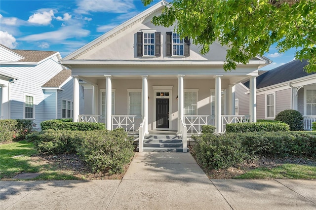 neoclassical / greek revival house with a porch and stucco siding