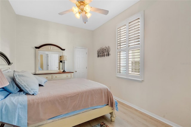 bedroom with ceiling fan, baseboards, and wood finished floors