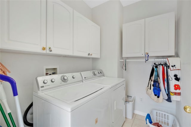 laundry room featuring baseboards, cabinet space, washing machine and dryer, and light tile patterned flooring