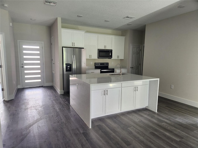 kitchen with white cabinets, visible vents, appliances with stainless steel finishes, and a sink