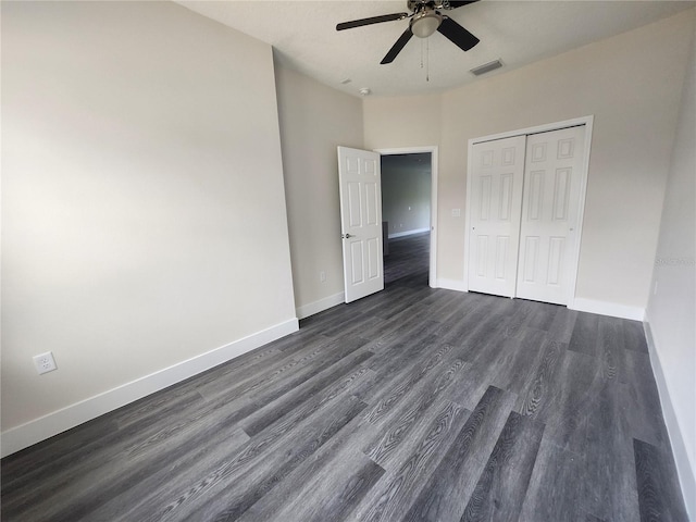 unfurnished bedroom featuring a ceiling fan, baseboards, visible vents, dark wood-type flooring, and a closet