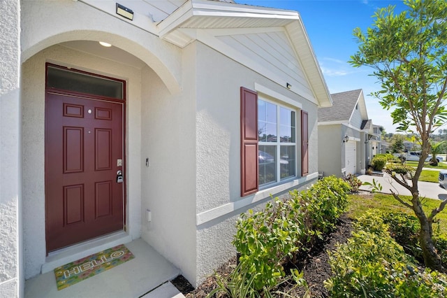 entrance to property featuring stucco siding