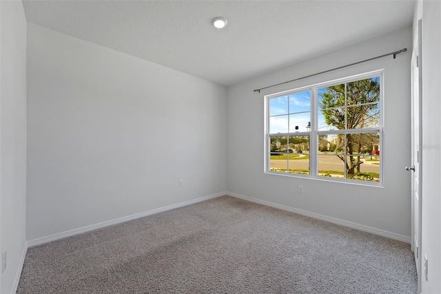 carpeted spare room featuring baseboards