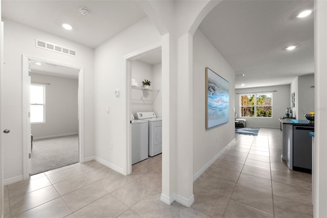 hall with plenty of natural light, separate washer and dryer, visible vents, and light tile patterned floors