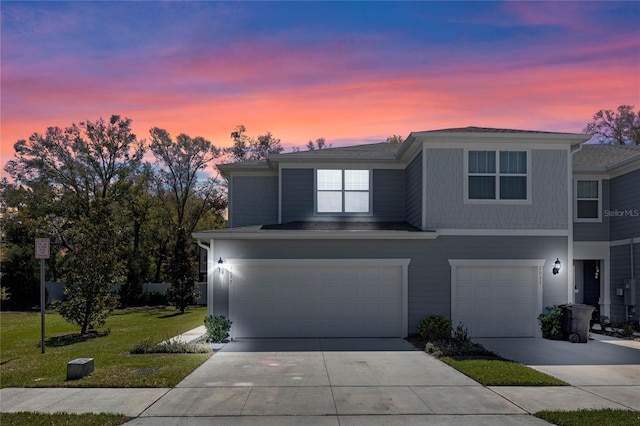 view of front of property featuring a yard, concrete driveway, and a garage