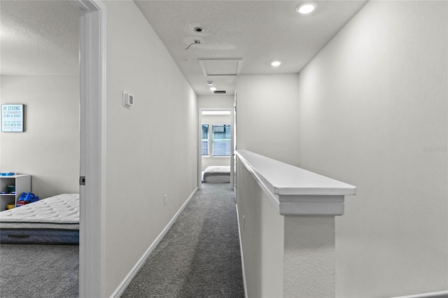 corridor featuring baseboards, carpet floors, an upstairs landing, recessed lighting, and a textured ceiling