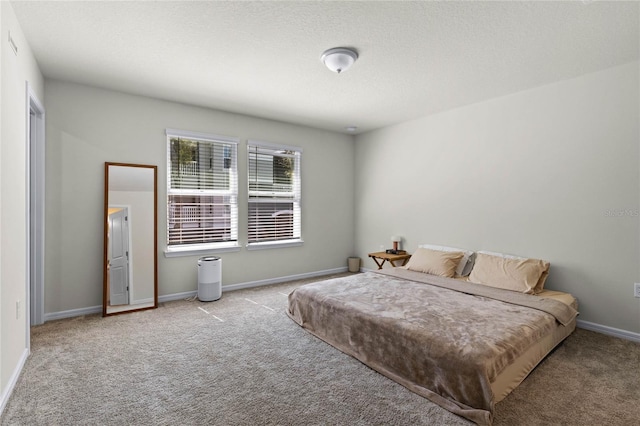 bedroom with baseboards, carpet floors, and a textured ceiling