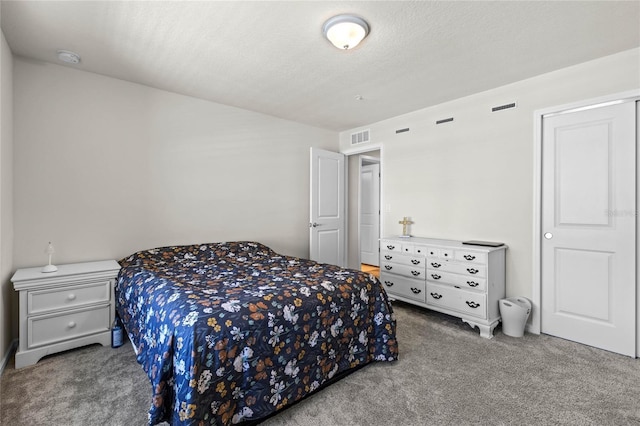 carpeted bedroom featuring visible vents and a textured ceiling