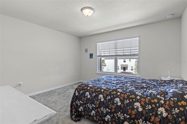 carpeted bedroom featuring baseboards and a textured ceiling