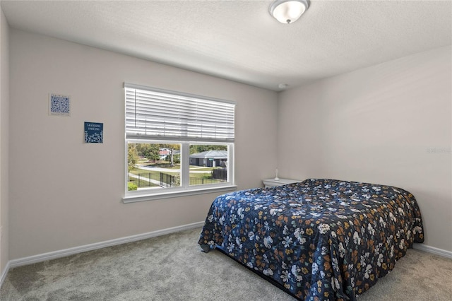 bedroom featuring baseboards, carpet floors, and a textured ceiling