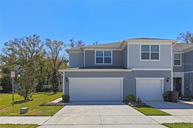 view of front of house with an attached garage, driveway, and a front lawn