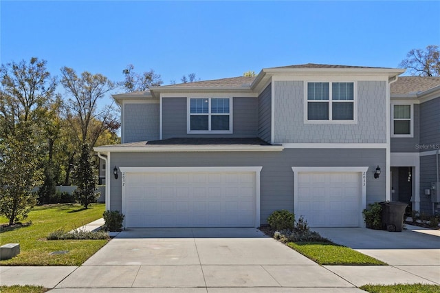 view of front facade featuring a front lawn, an attached garage, and driveway