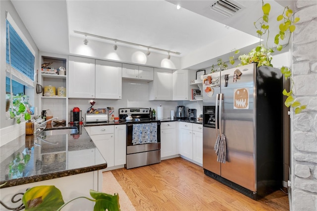 kitchen featuring light wood finished floors, visible vents, a sink, stainless steel appliances, and open shelves